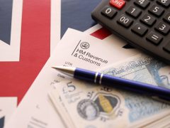 An HMRC form with £5 notes