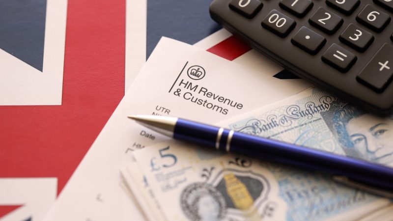 An HMRC form with £5 notes