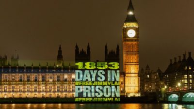 Free Jimmy Lai protestors project message onto Parliament.