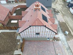 Drone view of a near completed semi detached first time buyer property within a new housing estate. The house insulation is currently exposed, soon to be covered