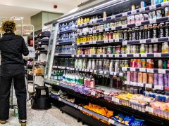 Woman stacking supermarket shelves