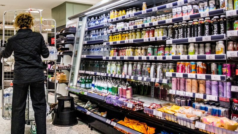 Woman stacking supermarket shelves