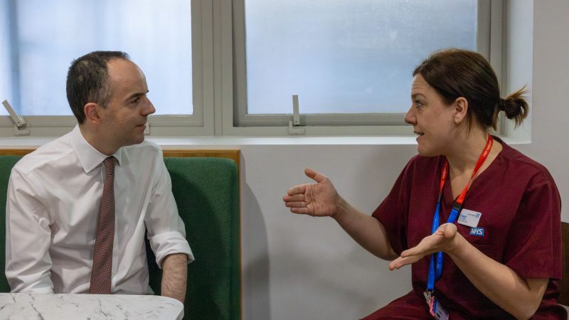 James Murray talking to an NHS worker in scrubs