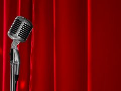 Old fashioned mic in front of red curtain for stand up