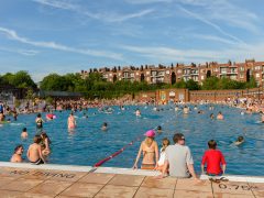 : People swimming on a hot sunny summer day in Parliament Hill Lido in Hampstea