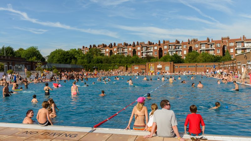 : People swimming on a hot sunny summer day in Parliament Hill Lido in Hampstea