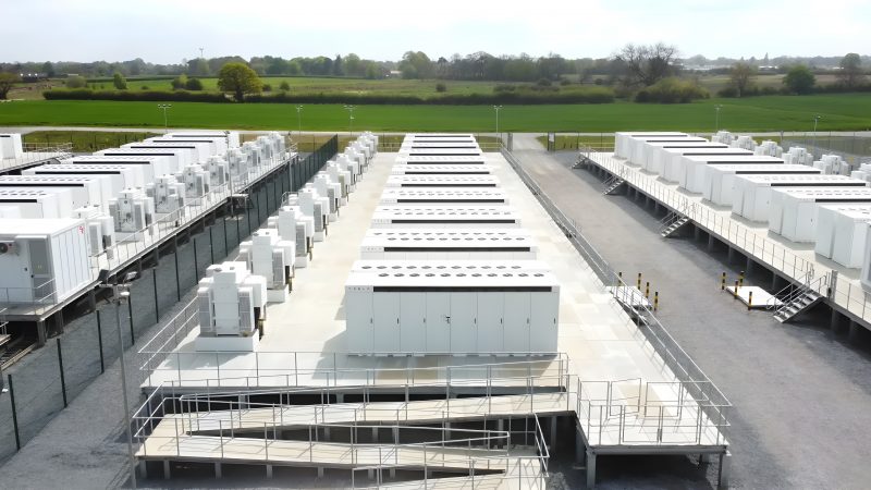 View of a large-scale battery energy storage park featuring multiple rows of battery storage units.
