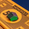 A stack of Monopoly money with a solo green house at the top.